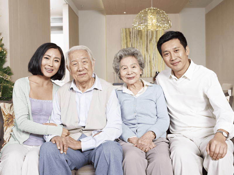 Older parents with their children sitting together on a couch